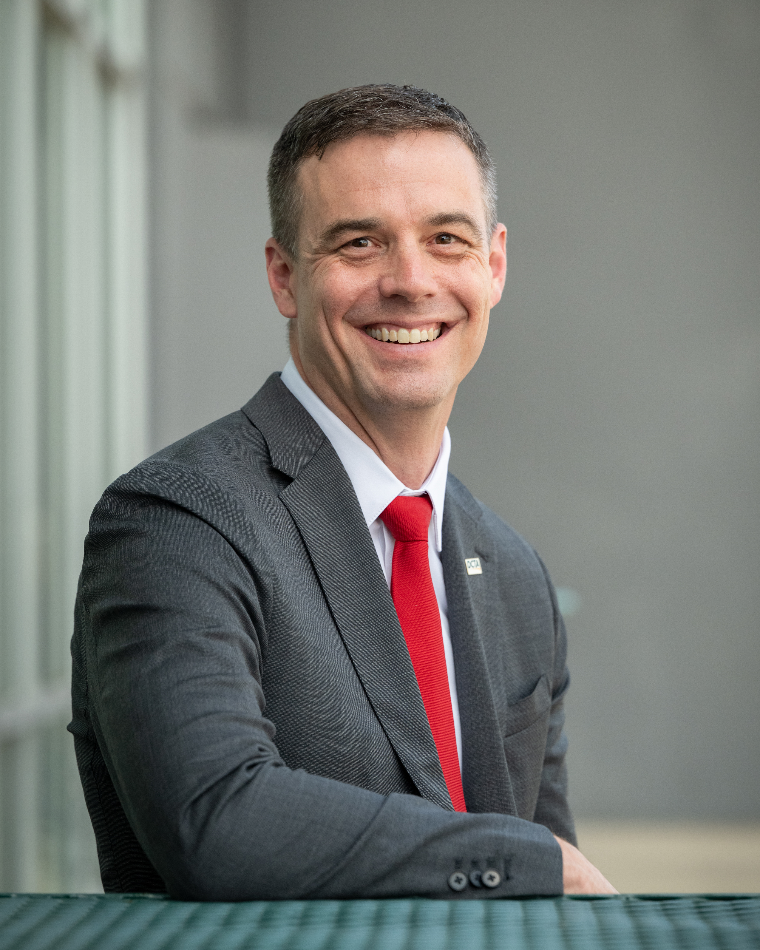 Headshot of Paul Cristina, President and CEO, sitting outside at the DCTA Bus Operations & Maintenance facility.