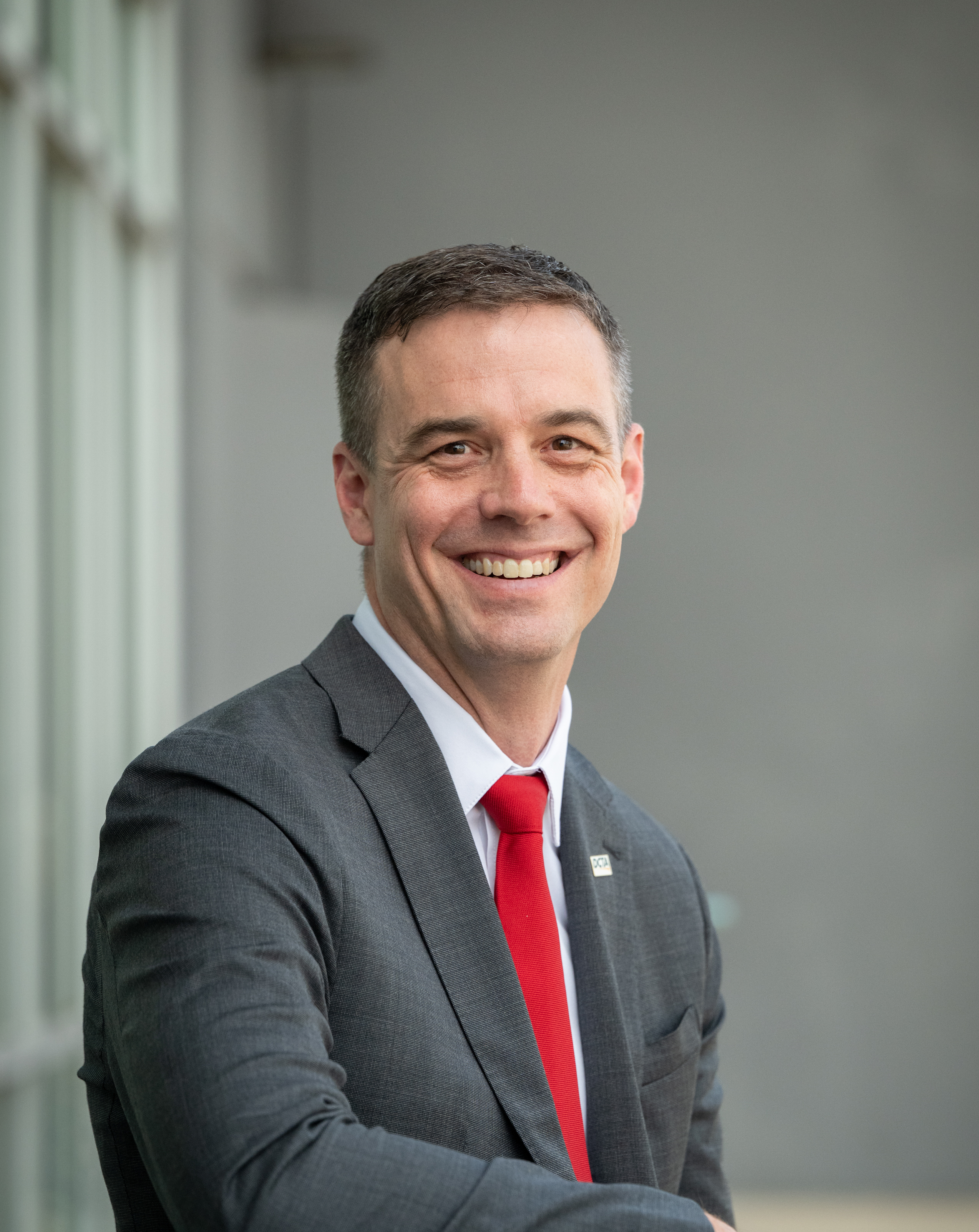 Headshot of Paul Cristina, President and CEO, sitting outside at the DCTA Bus Operations & Maintenance facility.